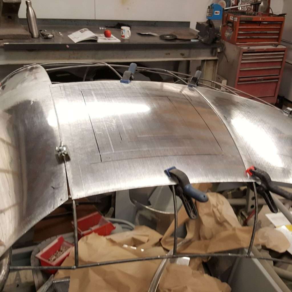 With precision, we work on flat aluminium sheets, marking out the double compound curve, skilfully using the English Wheel to form the desired shape for the 1953 Jowett Jupiter. It's a challenging process, but the end result speaks volumes.